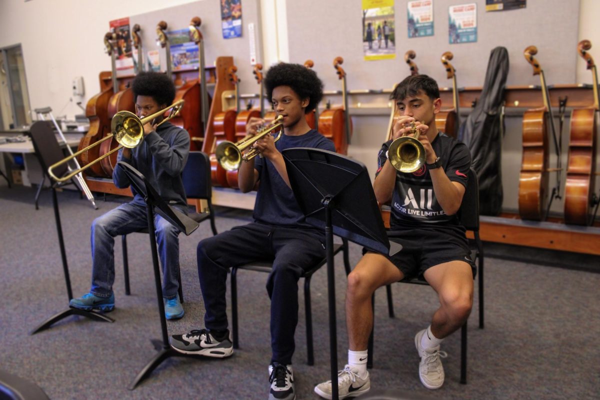 Bruce Bennett, Valentino Bennett, and Lorenzo Bianchi play music in Carlmonts band room. The three are among the handful of Nesbit Middle School students that went on to join Carlmonts music program.