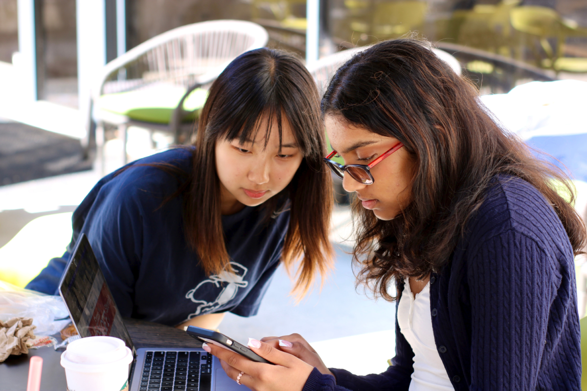 Sophomore Anagha Namburi shows her friend, Ellen Li, a picture of a shirt she found online. After getting food from the Carlmont Shopping Center, they joined Westwood and their other friend, Lily Stutzin, outside. Its a common place to hang out and a good place to study, Namburi said.