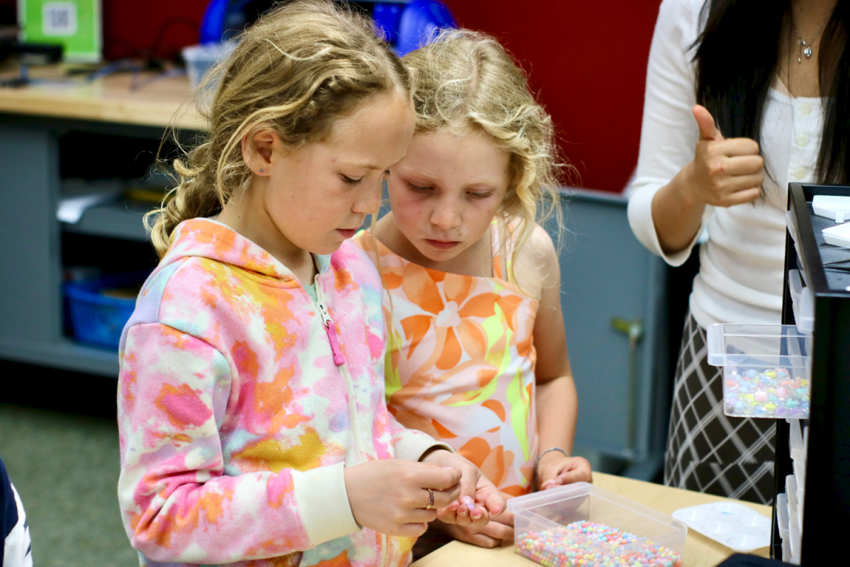Two girls assemble their bead necklaces. Apart from jewelry-making, the Maker Hangout offered laser cutting, 3D printing, and Procreate drawing on iPads. The Maker Hangout is an event for people of all ages, from kids who come with their parents to Carlmont students who come with their friends.  