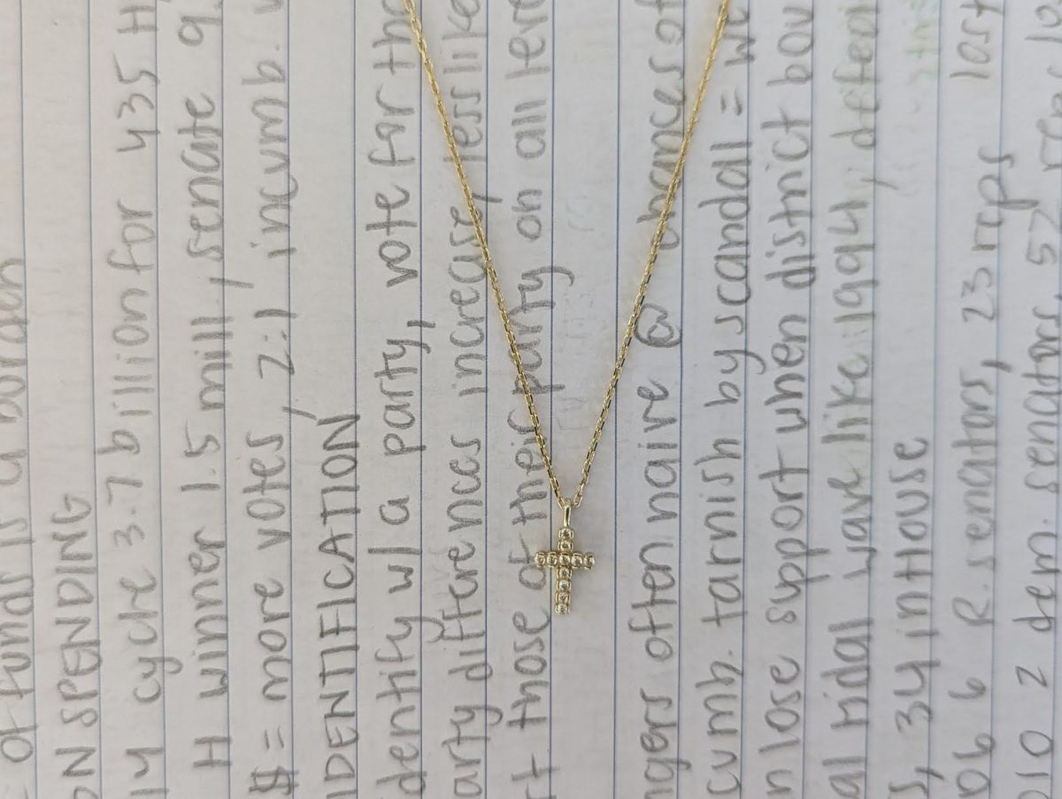 A cross necklace drapes over a student's homework. Many have continued questioning the extent to which religion belongs and schools, and whether incorporating one religion into classrooms at the expense of teaching all from an objective standpoint is harmful to students. 