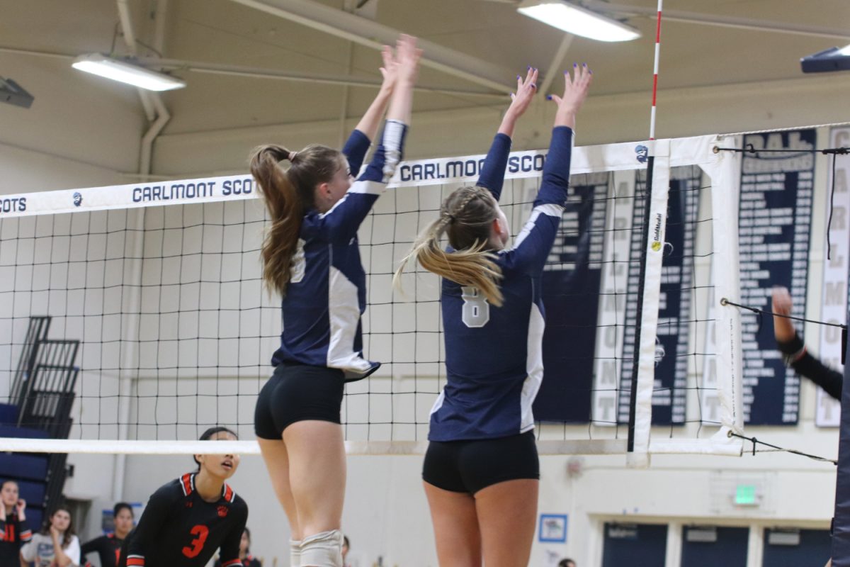 Seniors Annika Snow and Mia Hariri-Turner jump up to block the ball in the first set. They stopped San Mateo from gaining a point and later their team scored on this rally. 