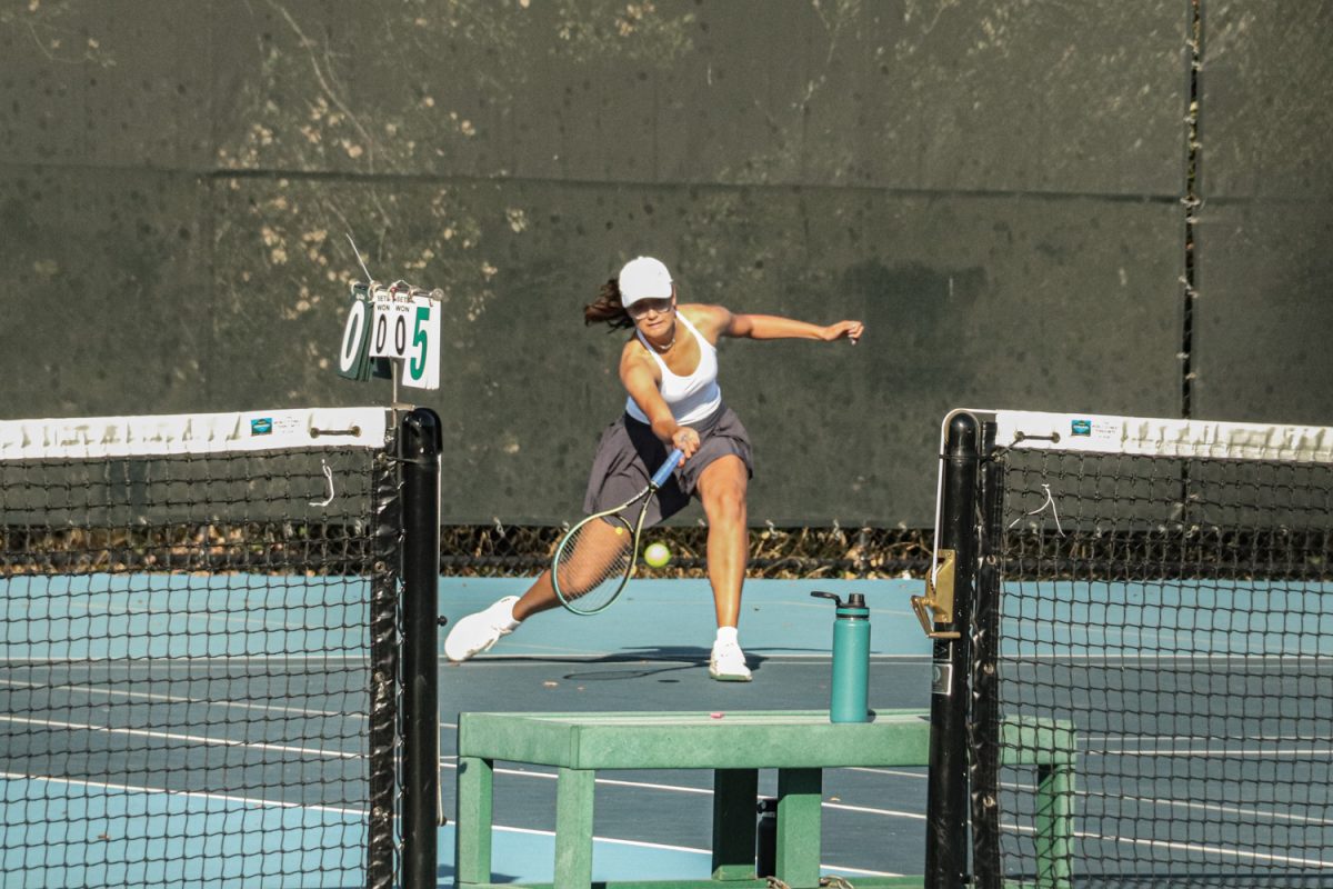 Junior Megan Bence performs a half volley on an approaching ball. With this shot, Bence brought the opponent toward the net, putting offensive pressure on them. This allowed her to secure the point, which ultimately led to her winning the match.