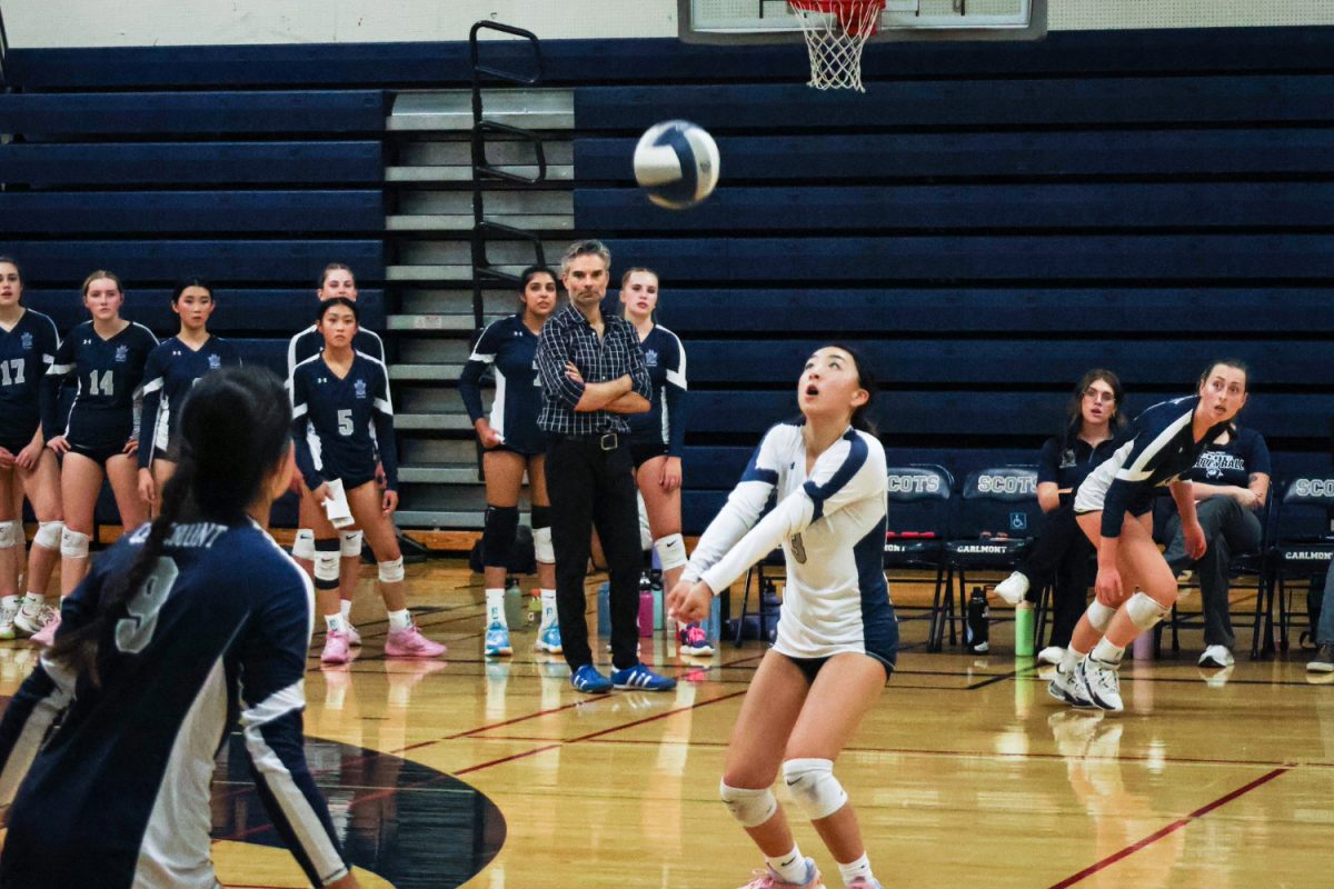 Sophomore Amber Lee helps set up an offensive maneuver after defending a spike. Lee is the team's libero, who is typically the central receiver of serves, and the second line of defense against attackers. Liberos act as the backbone of the team as they are typically solid passers, helping their team to set up a proper offense.