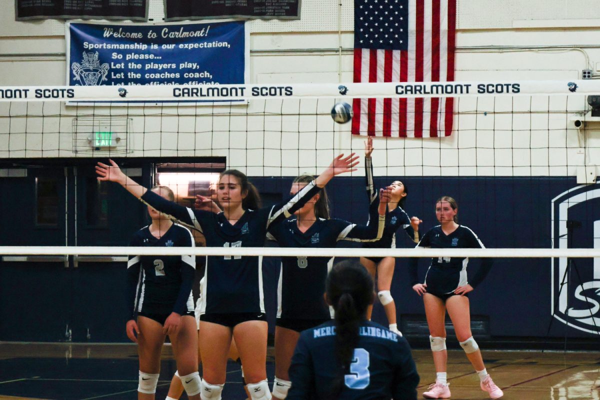 Snow and junior Olivia Pasion raise their hands in front of the net with the server serving behind them. "I really think it's kind of performative," said Noelle Pecavar, a player for the JV volleyball team. "The strategy behind it is where you're supposed to hide your server and make it harder for the passers to see the ball."