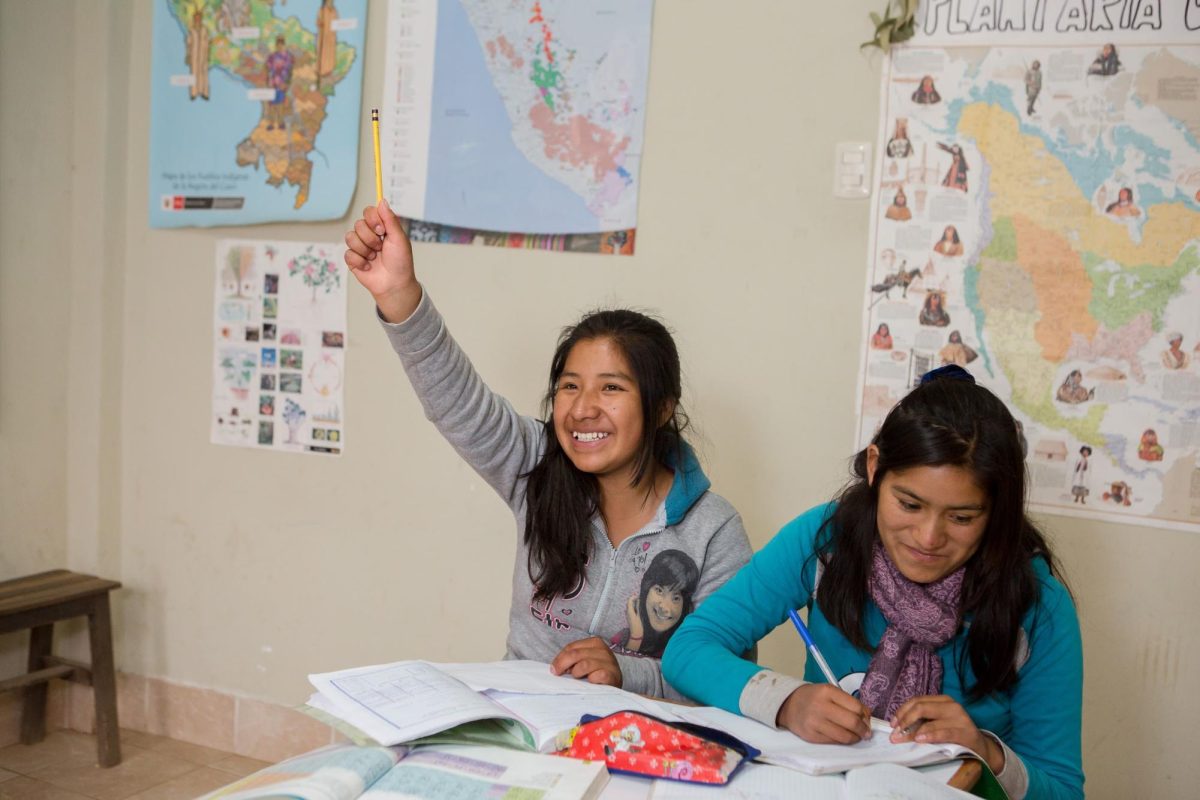 Girls sit in a classroom at the Sacred Valley Project, actively participating in a tutoring session. Students have the option for academic tutoring every day of the week except Fridays. 