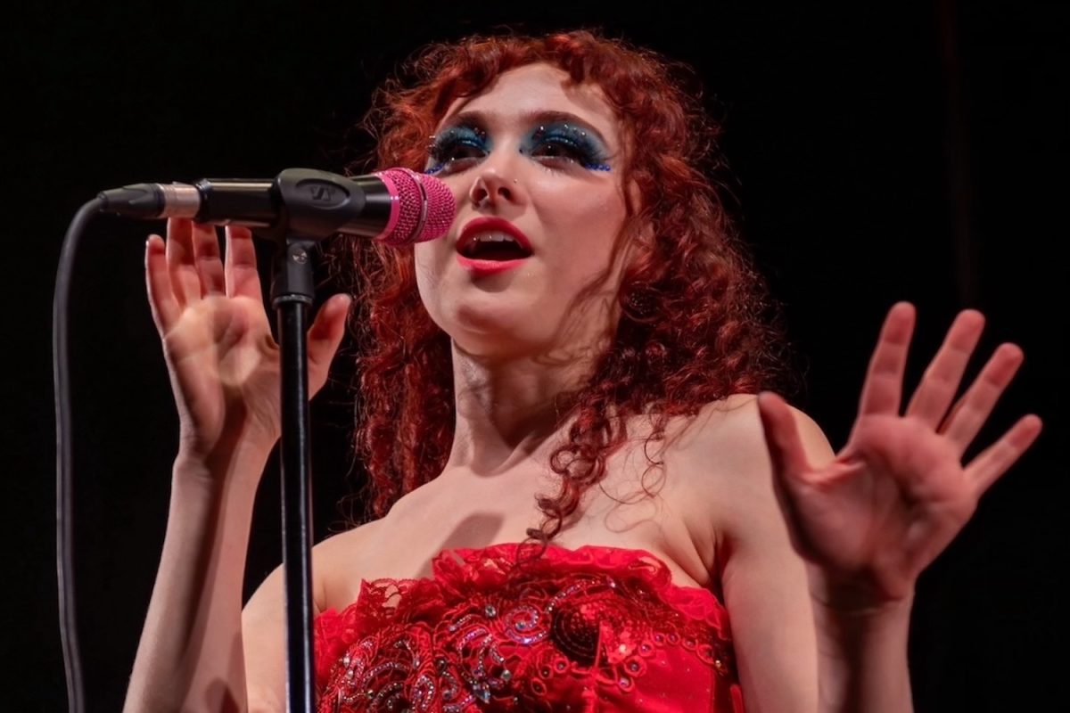 Chappell Roan sings to an audience at Hollywood Palladium in an elaborate outfit and bold makeup. With her newfound fame, Roan serves as a role model for her young fans in the LGBTQ+ community.