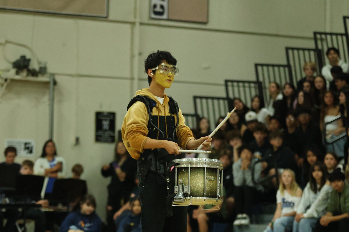 Junior Jiho Park, dressed as a minion from the movie Despicable Me, plays drums during the drumline performance.