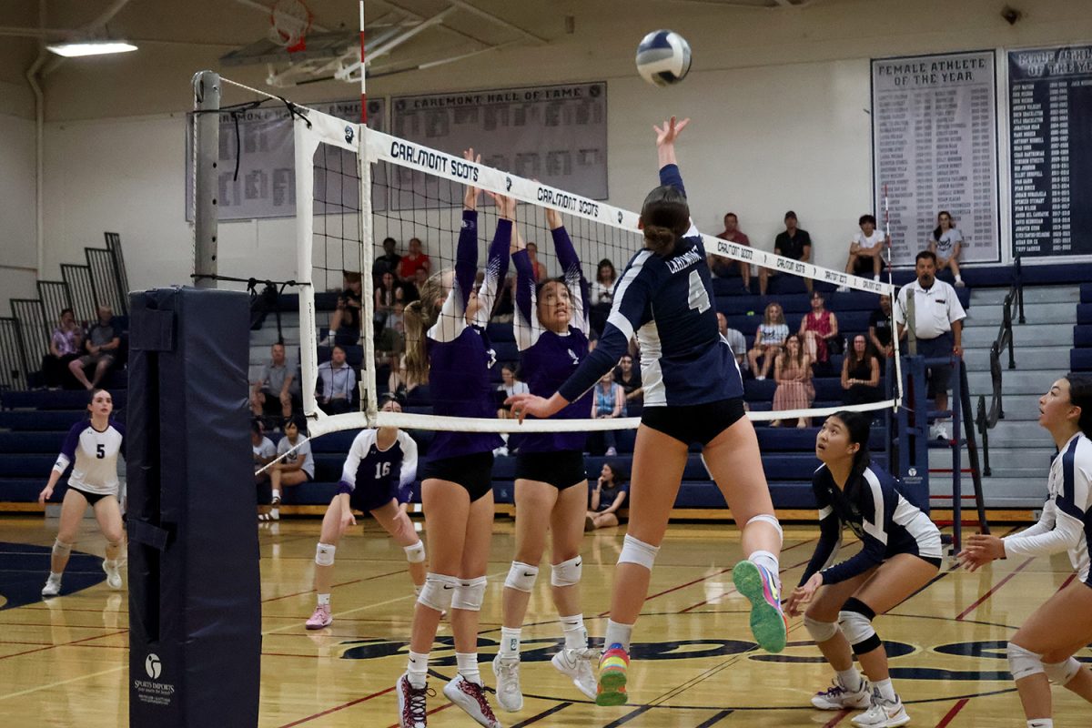 Senior Alexandra Bieser floats up as she reaches for the ball. Anticipating a spike, the Sequoia blockers jumped quickly above the net. Bieser instead tipped the ball over the defenders for a point.