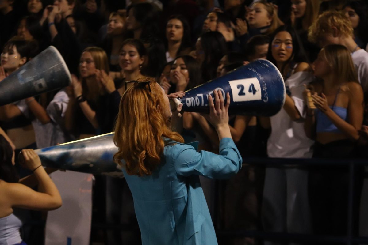 Shane Fitzpatrick gets the student section energized alongside other screaming scots members. Students get together during the homecoming football game and celebrate a win. 

