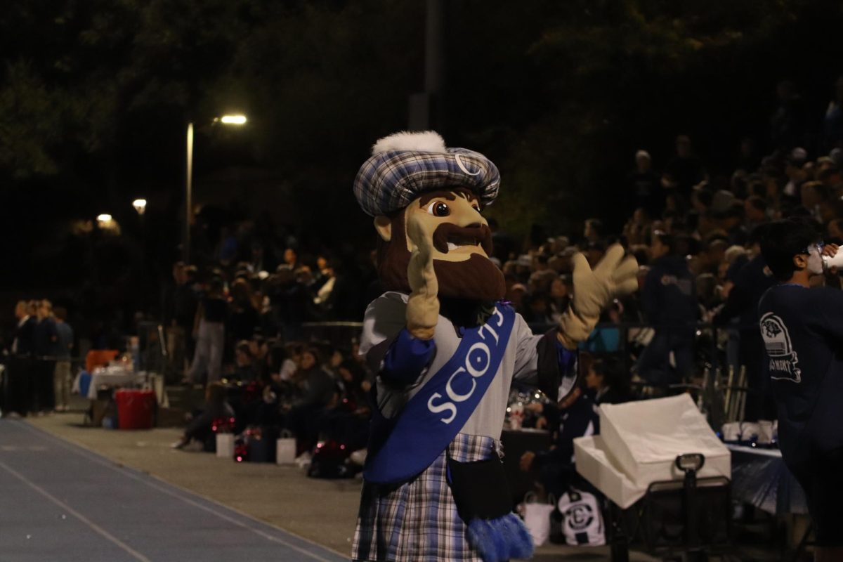 Carlmont's mascot, Monty, cheers on the student section crowd along with the sideline Screaming Scots.