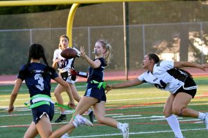 Greene laterally passes the ball to Tow to continue the play. Greene ran for the longest she could before her flag was about to be pulled before tossing the ball to her teammate. This maximized the amount of yardage that the Scots gained in a single down.