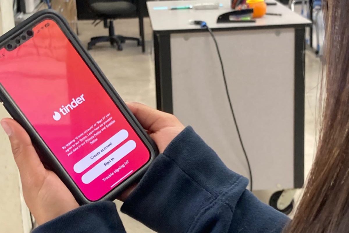 A student opens the Tinder app on her phone and prepares to set up her account. Tinder has repeatedly ranked as the most popular dating app in the world. 