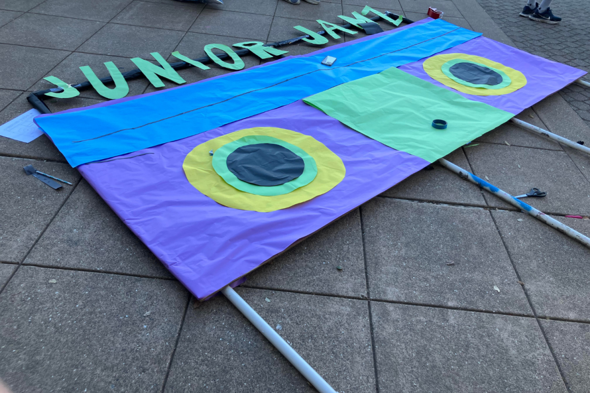 A poster for the junior float waits in the quad to be worked on. The bright colors and fun design contribute to the festive themes of homecoming.