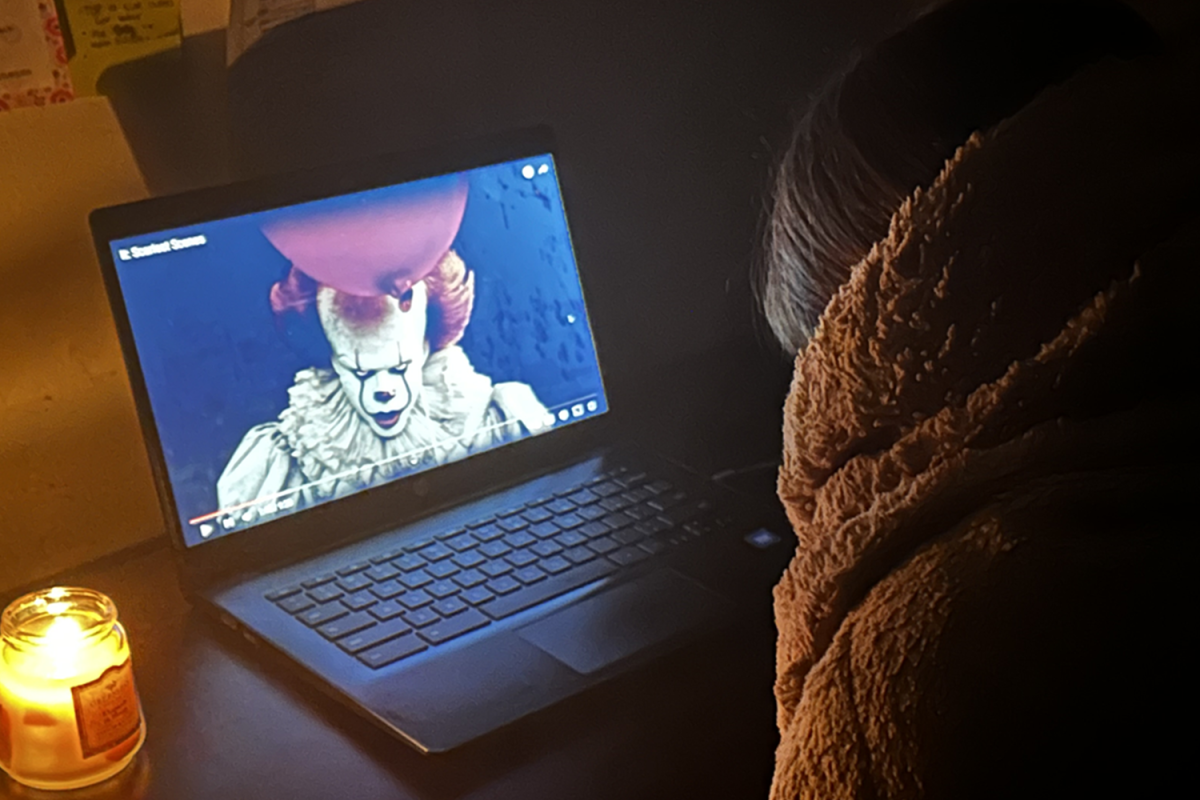 A teenager watches the movie "IT" with a blanket around her.
 "I think people like scary movies because you can never expect what's going to happen. It's very thrilling, and it'll keep people hooked on what's next," said Mia Marcos, a sophomore at Carlmont High School.