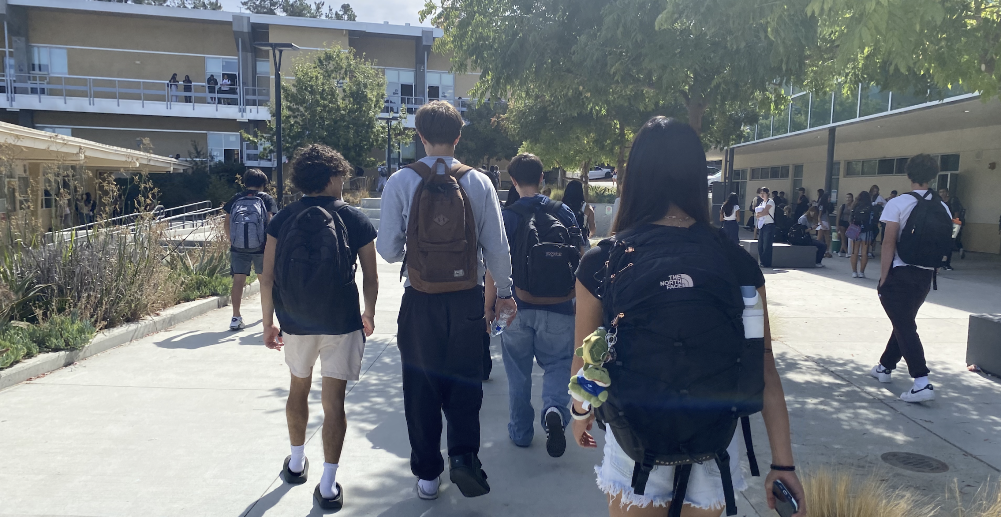 Students of tread toward their classes near the U building as the final bell of the passing period approaches. The ring of the bell provides a structure to the students' daily lives, marking the transition between one class and the next.