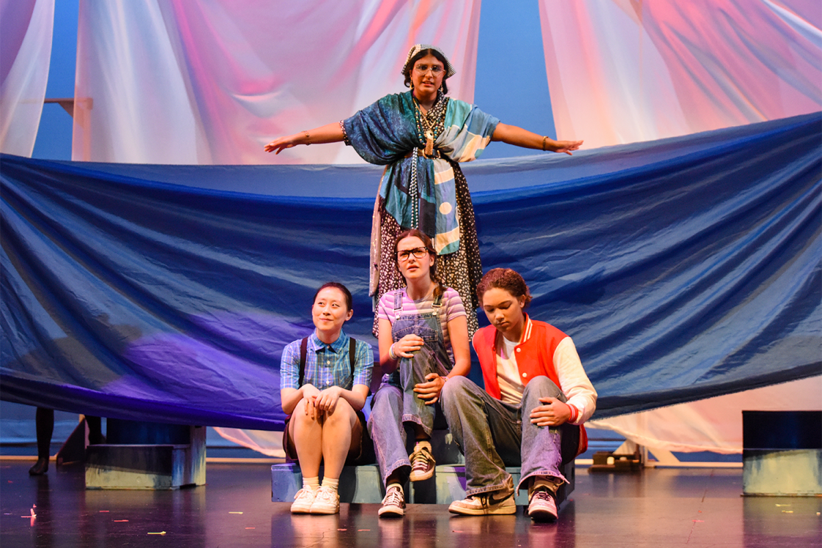 Mrs. Whatsit (Ryu Shukla) transforms into a bird allowing main characters (left to right) Charles Wallace Murry (Jessica Li), Meg Murry (Milena Hanson), and Calvin O'Keefe (Colin Crockwell) to hop on. This is one of the first scenes of the show, and it establishes a mood of wonder for the rest of the production.