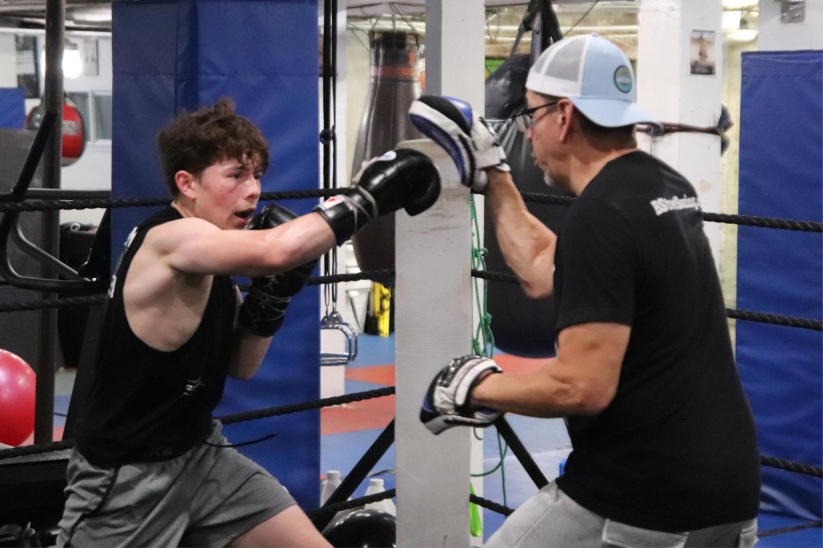 Camilo Barberena swings for his coaches' mitts during practice. During this drill, Barberena had to throw combinations to improve his speed and accuracy. His coach Freddy Silva constantly gave positive feedback to help his fighter.