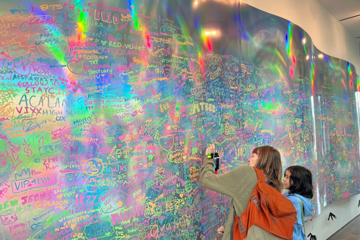 Museum visitors add their bias names to a metallic mural at the exhibit. In K-pop, a "bias" refers to one's favorite group group member. "The biggest groups currently for girl groups are Aespa, New Jeans, Blackpink, and Twice. For boy groups, they are Tomorrow by Together (TXT), Stray Kids, and BTS," To said.