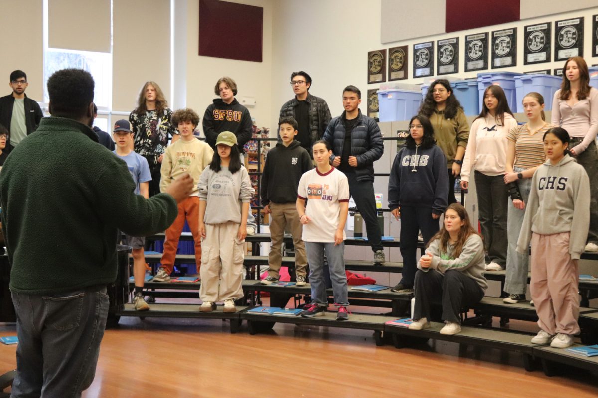 Dario Johnson, Carlmont's vocal coach, leads Concert Choir through vocal warmups. Members enjoy a sense of community and inclusion in this musical refuge.  