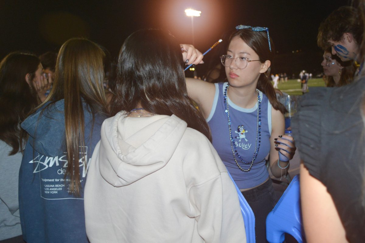 ASB Publicity Commissioner, Alexis Mayberry, paints a student's face. 