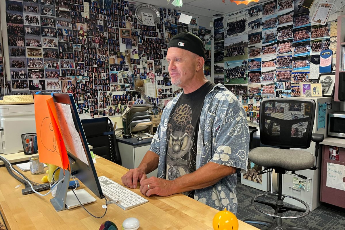 Decked out in spirit wear, Jim Kelly works at his desk in preparation for the Homecoming Assembly. As the activities director, Kelly spends lots of time working with his students to pull off various events at Carlmont. 