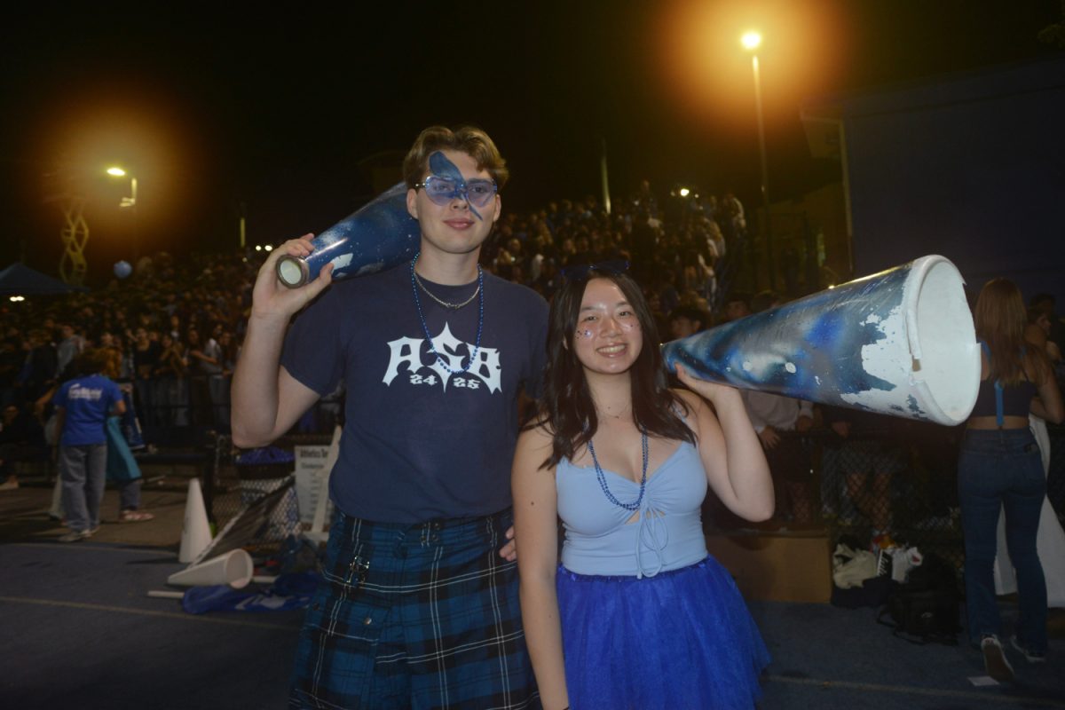 ASB Executive Board members Walker Fort and Caelyn Cheng take a break from leading student section cheers to pose with their bullhorns.