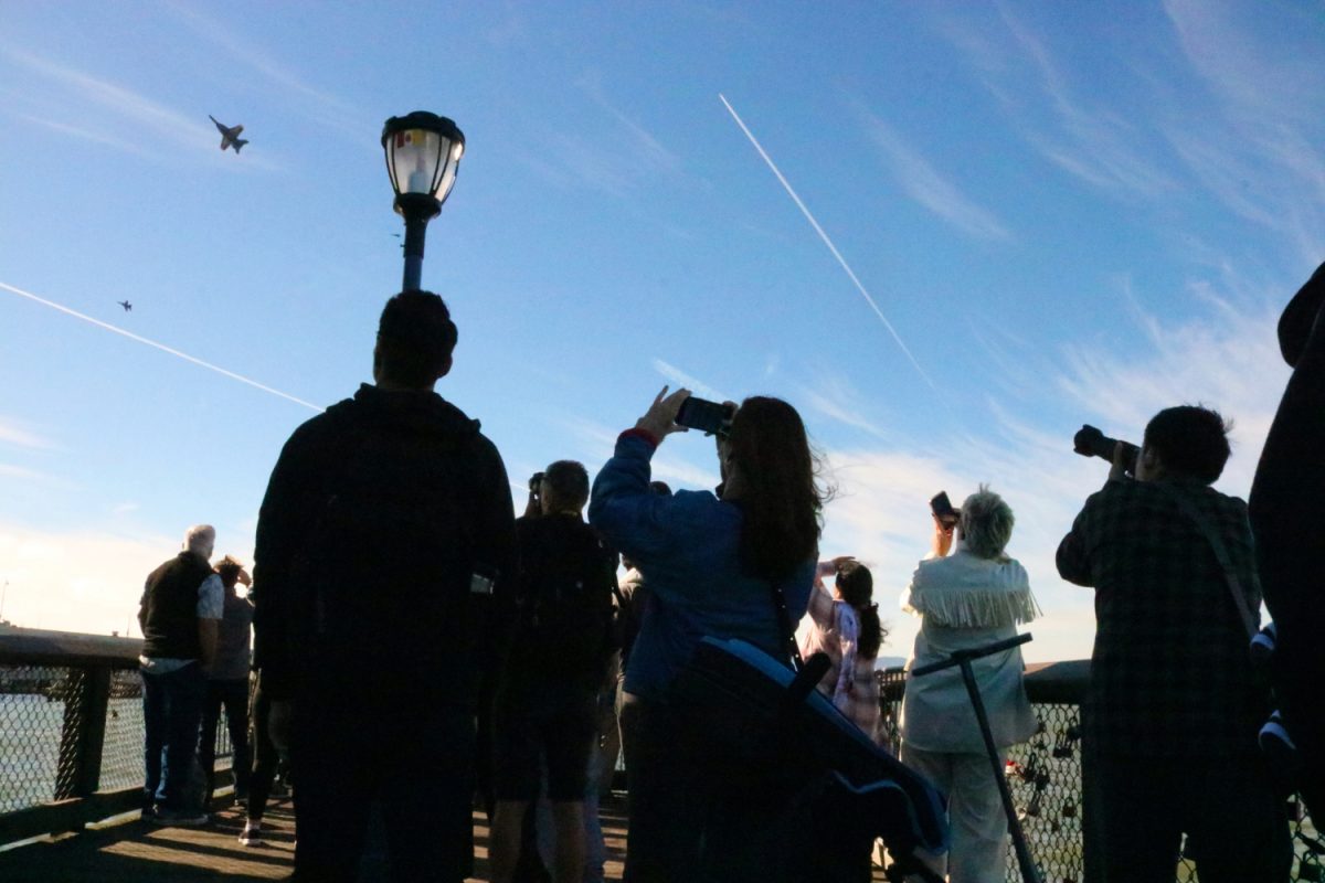 Spectators of the Blue Angels show during San Francisco Fleet Week track the fast-moving planes as they change formations. The breakaway movement the pilots perform demonstrates speed and agility.