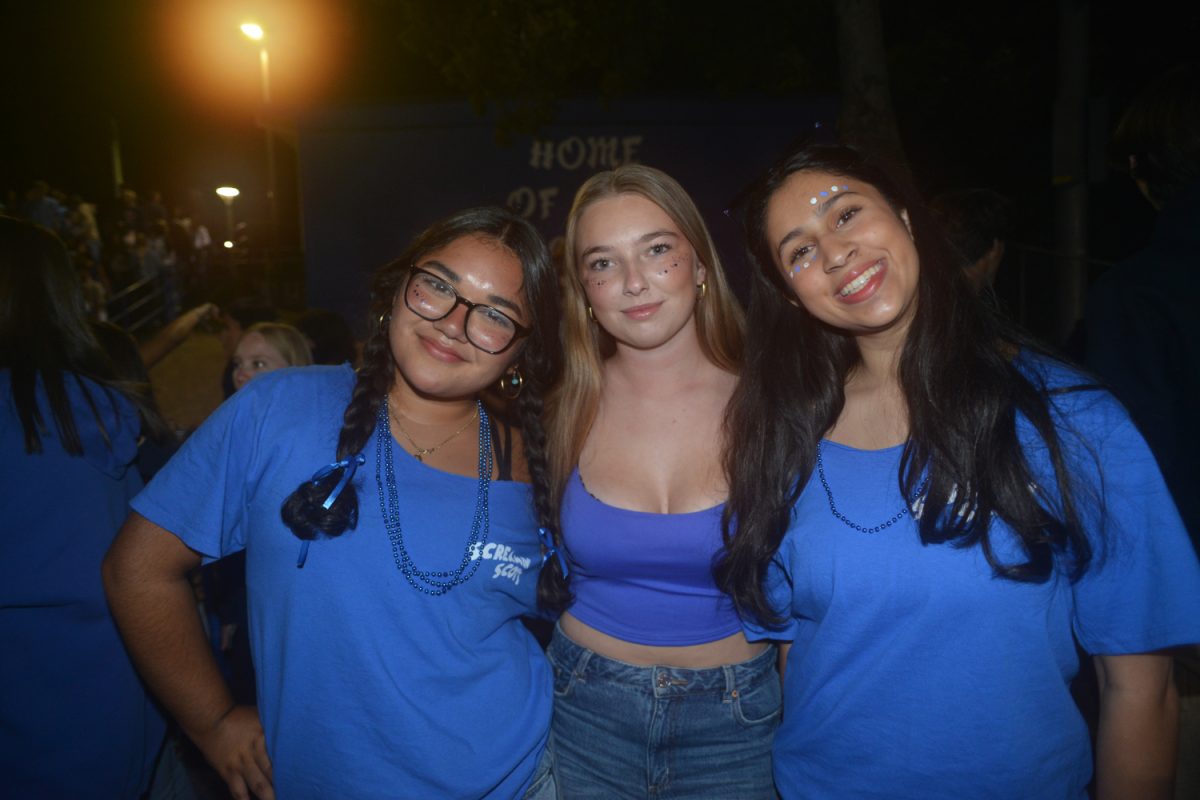 Seniors Luana Tellez, Masha Rozenfeld, and Anuja Kamatkar smile for a picture on the sidelines.