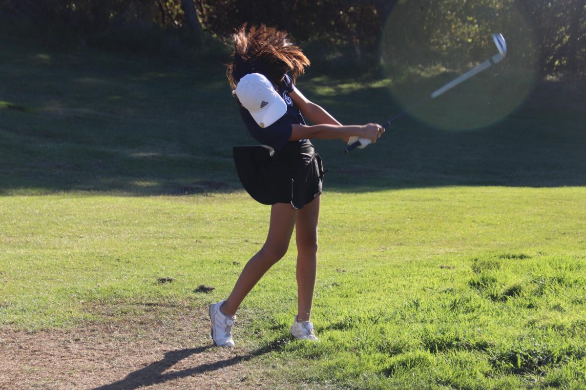 After her drive finds the fair way, Tessa Lee strikes the ball on a steep hole six. With the windy currents, the ball landed a chip away from the green. With a chip and and a putt she was able to par the hole.