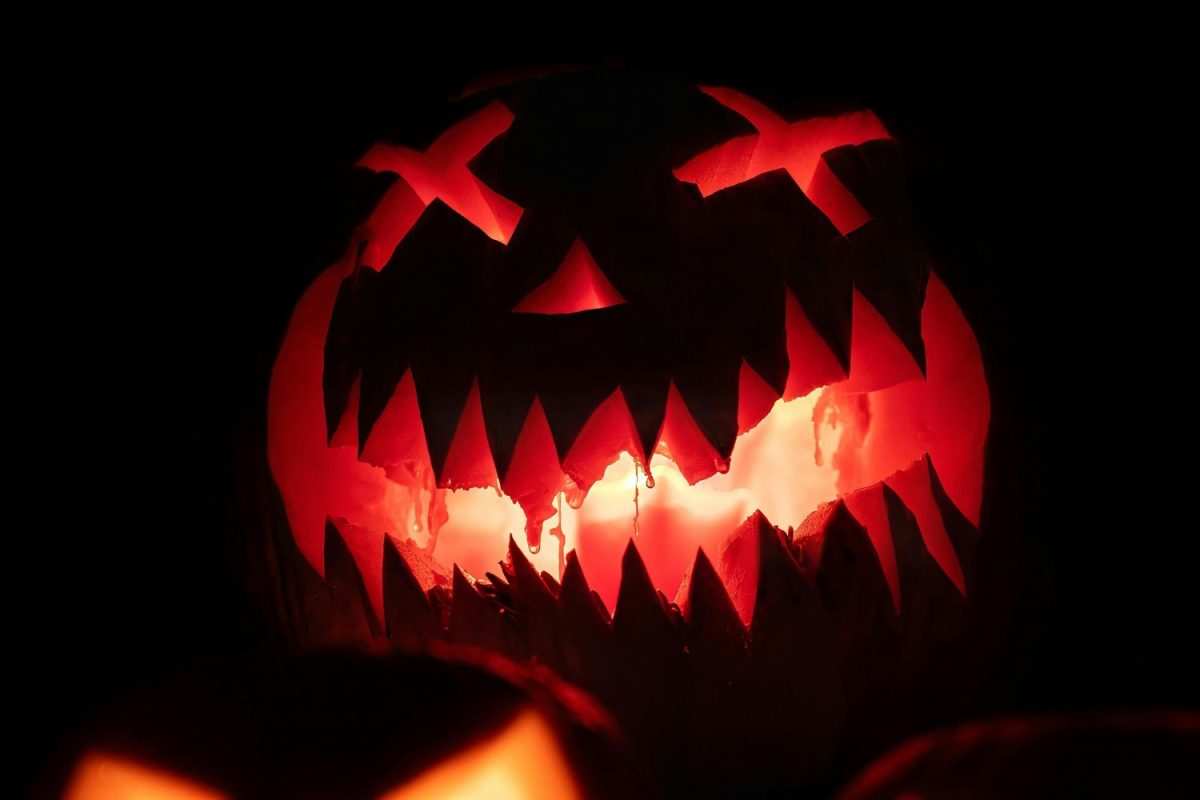 A jack-o'-lantern featuring ominous lights illuminating from within. The jack-o'-lantern is an iconic part of the Halloween season and resembles the relationship between horror and Halloween.