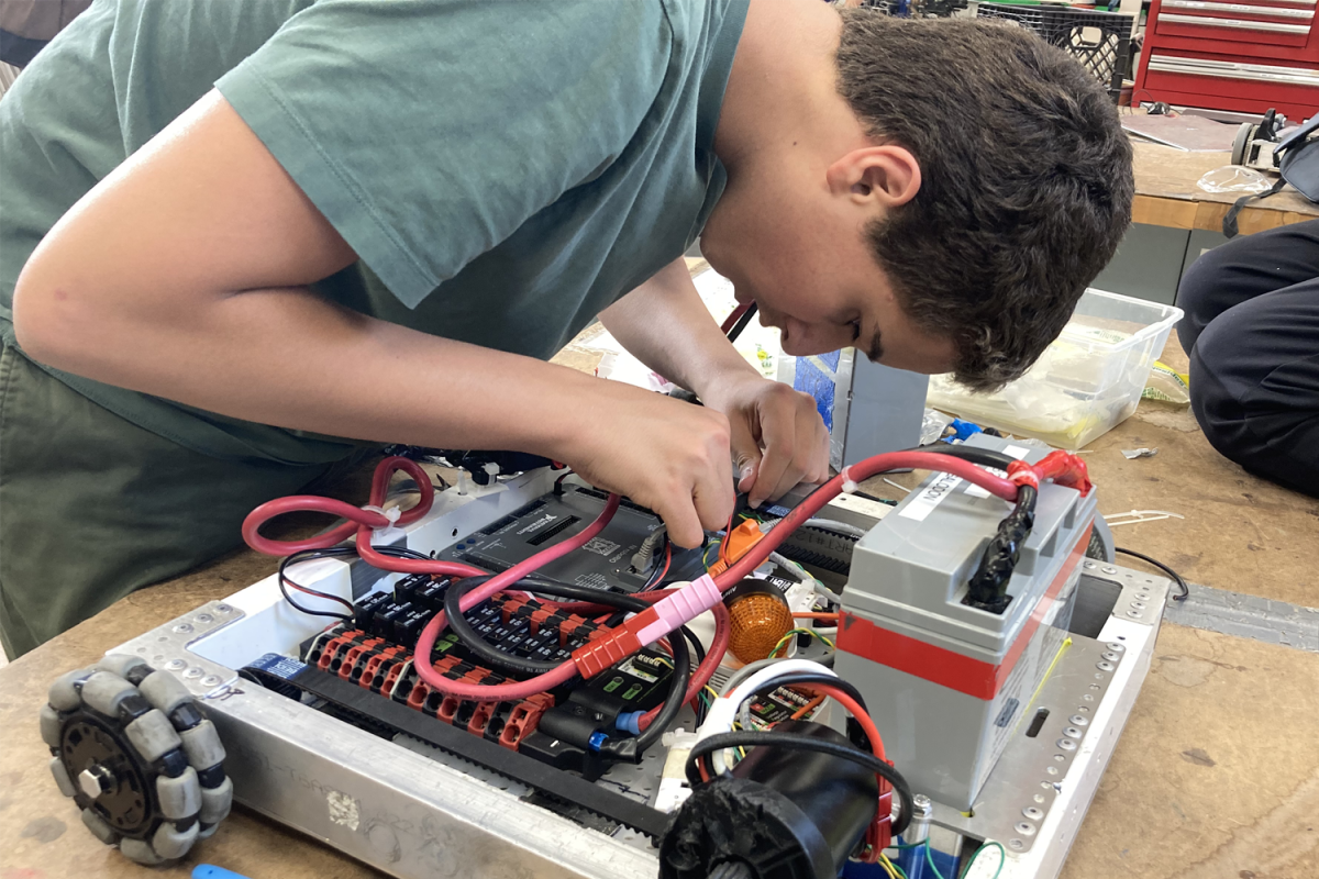 Daniel Tolkachov, a freshman and rookie on the team, reorganizes various wires on his team's prototype. The goal is to make sure none of the wires come loose and get caught in the wheels.