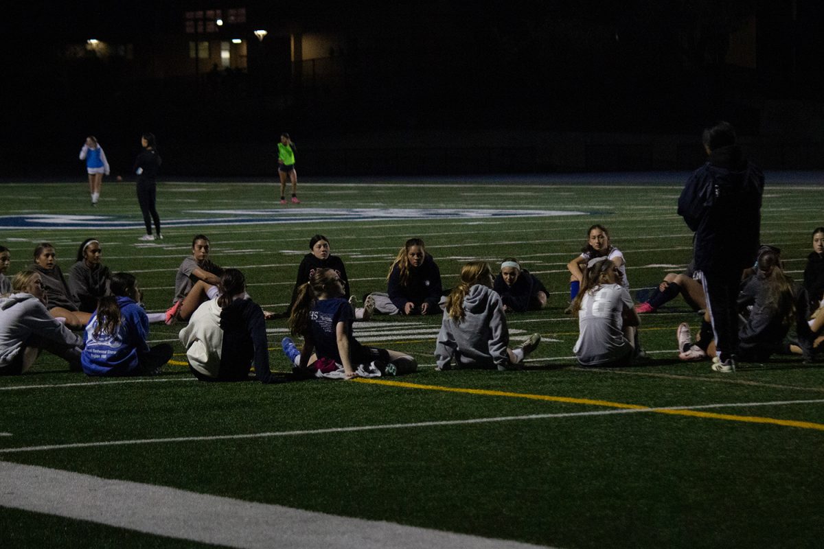 The players sit together and listen to coach Natalia Manzanares after warmups. With team chemistry being important in any sport, it was good that a lot of people were friends. "A lot of people there already knew each other, and everyone is pretty supportive and helps each other out," said freshman Evie Buhl.