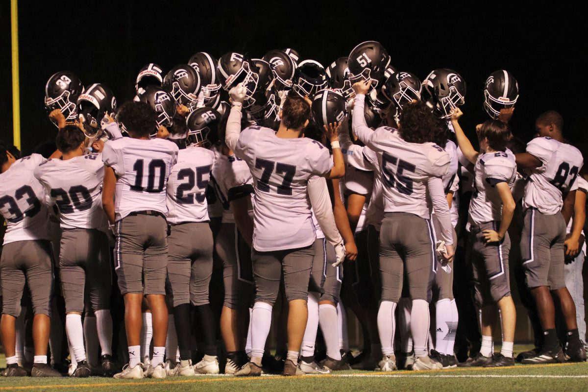 The Carlmont varsity football team huddles for a talk after a game.