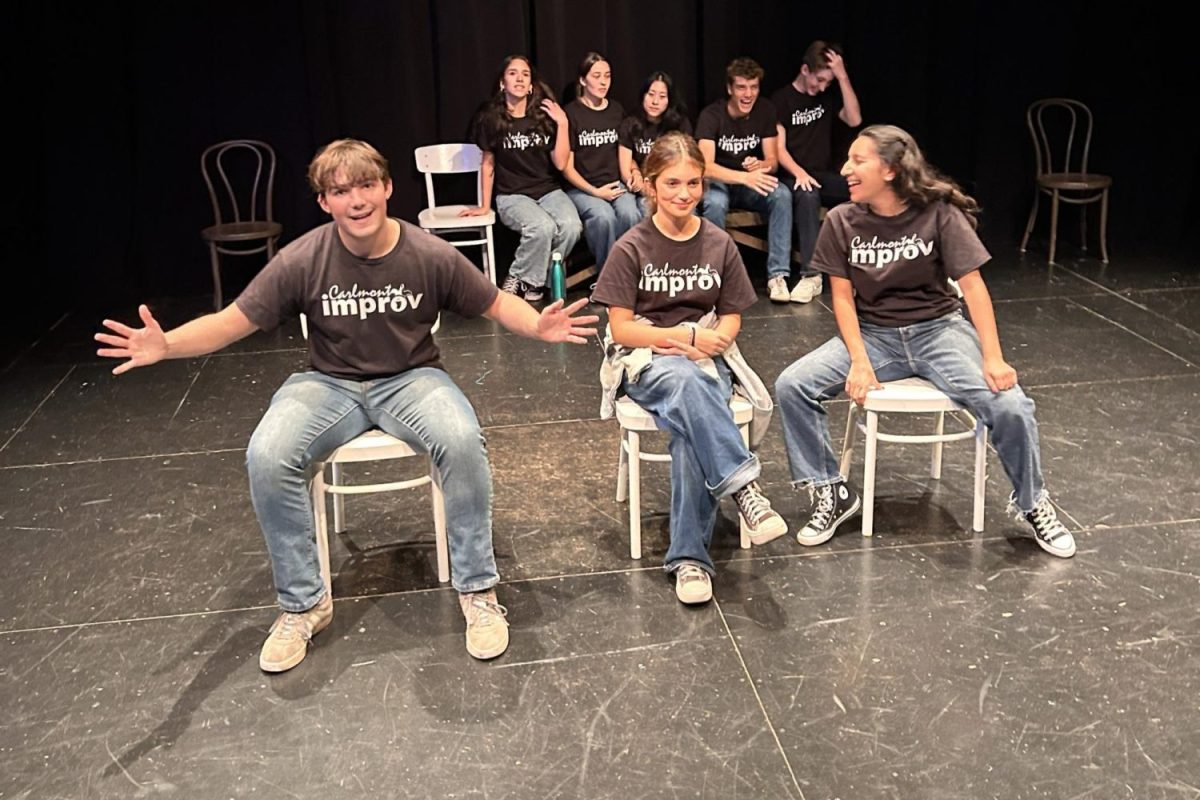 The Carlmont improv team sits side-by-side, sharing laughs and final tips right before their show. The anticipation to perform filled them with excitement. 