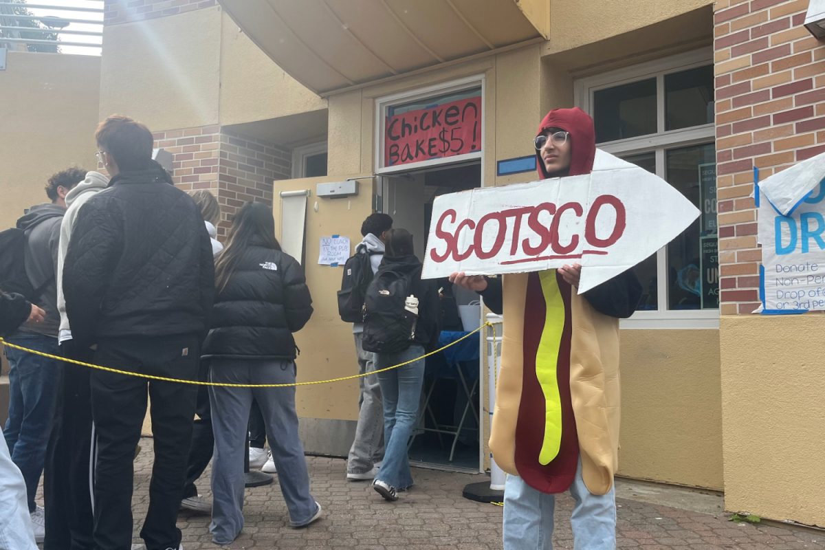 Freshmen class officer Kerim Lahmar holds a sign advertising Scotsco while dressed in a hot dog costume. "I love that students allow their creative expression to take place. I loved the details that they included such as the name tags and aprons," said Administrative Vice Principal Gregg Patner.