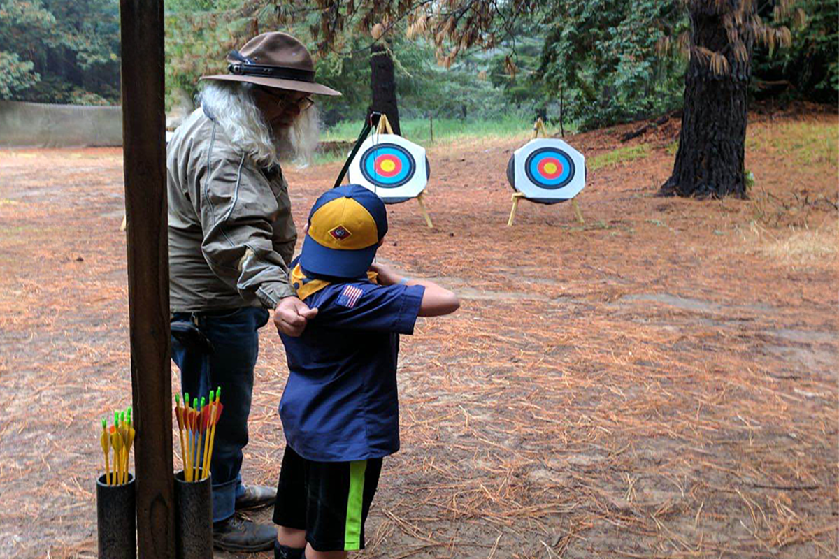 A young Cub Scout practices archery. Archery is an activity that was at the Scouts BSA council Gold Rush event. Gold Rush takes on an 1800s theme and includes activities that challenge a Scout's skills.