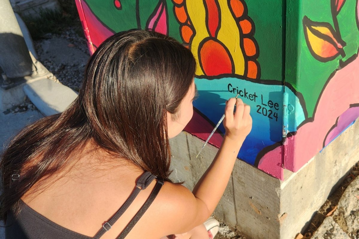 Cricket Lee signs her mural, in which she used acrylic paint to create. She did not use a reference photo for her design, but rather used her best judgment. "I just did it off of what I thought it would be," Lee said. 