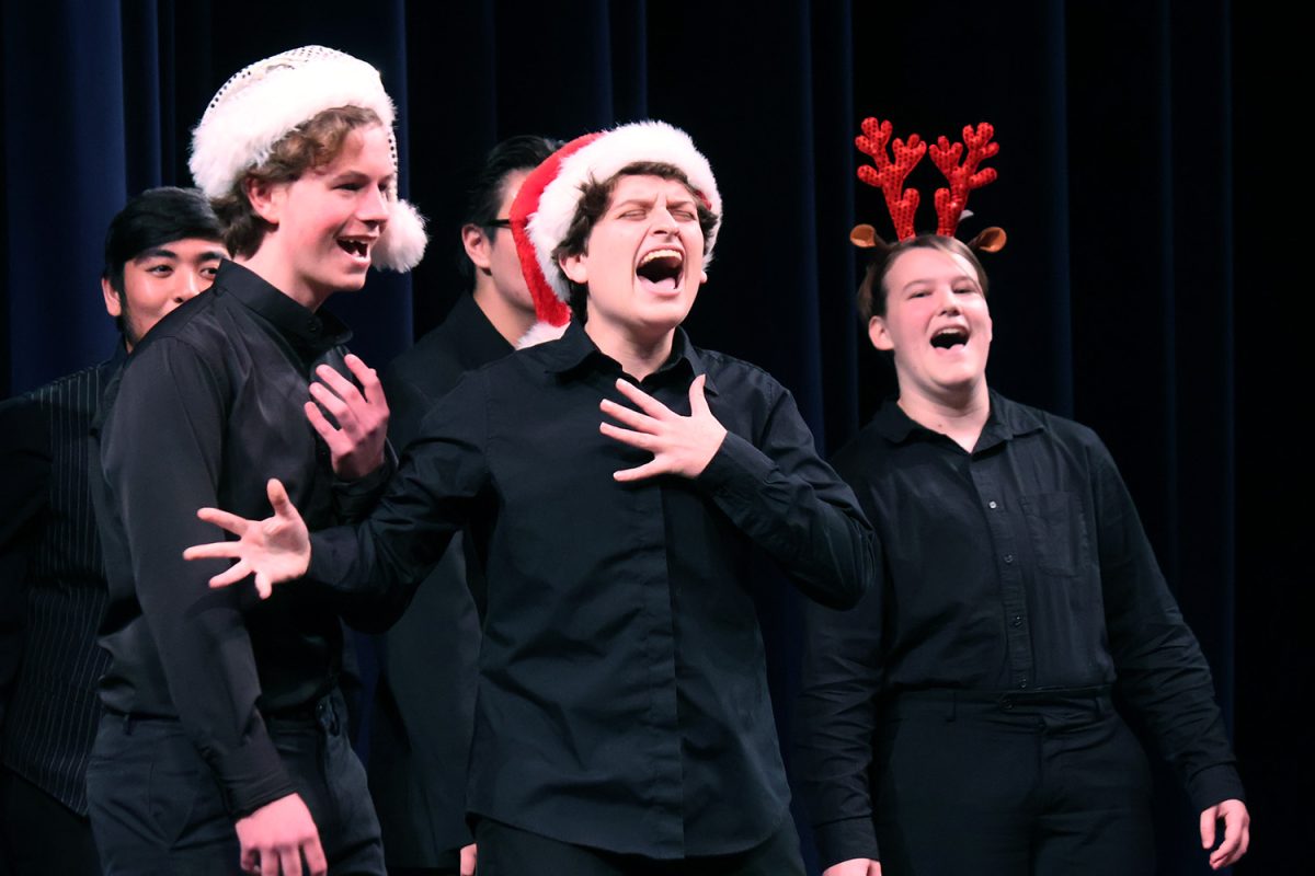 Senior Zoe Banner-Haimes interrupts a group member by belting out a note. Banner-Haimes is a member of the a cappella group “Fine Tuning.” They performed a rendition of “Twelve Days of Christmas” that got the audience laughing.