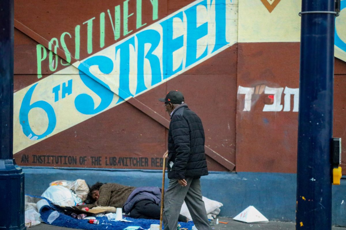 A man walks by a homeless person on the corner of Sixth Street and Natoma Street in the SOMA District of San Francisco. The SOMA District has become a hotspot for crime in San Francisco, causing it to be overrun by many of the city's unhoused.