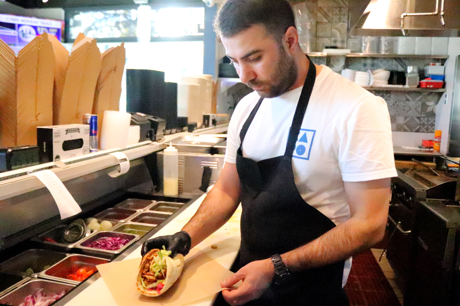 At Capo, a chef prepares the Spitfire Chicken Pita, one of the restaurant’s most popular dishes. Made with fresh ingredients and bold flavors, this favorite keeps customers coming back. “You can tell they put their heart into this meal, it’s like tasting a piece of their story,” said Coco Tomita, a customer. 
