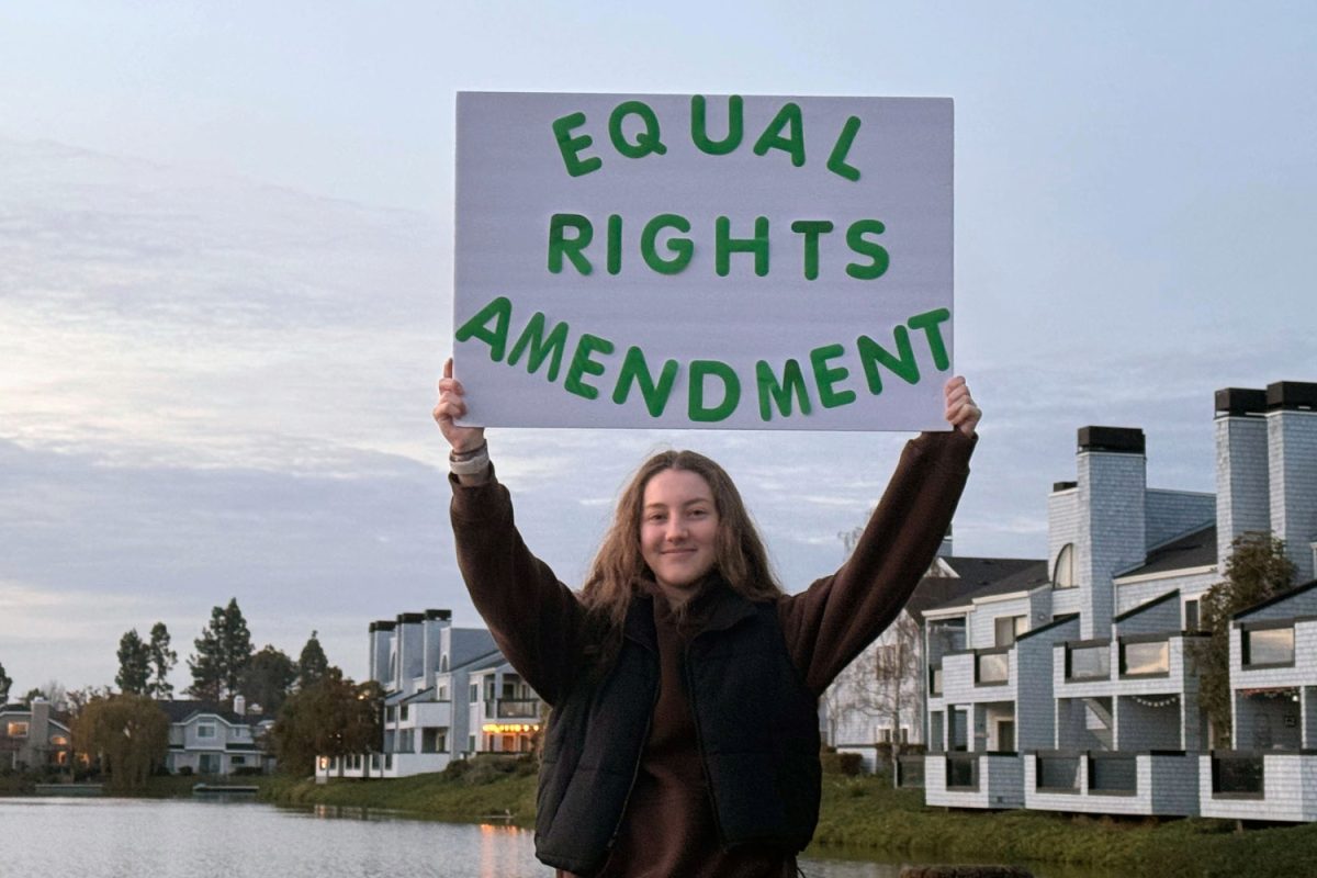 A student, Sara Yeretnov, holds an ERA sign in support of the amendment. Many students don't know what the ERA is and that they don't have equal rights protected by the U.S. Constitution.