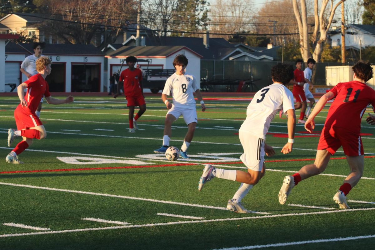 Carlmont seniors Donovan Dooley and Shawyaan Hajebi Tabrizi execute a wall pass during a fast-paced attack. This technique has been crucial in their offensive strategy, demonstrating their chemistry developed over years of playing together. In soccer, a wall pass involves a quick one-two exchange of the ball to bypass defenders and create space for attacking opportunities.