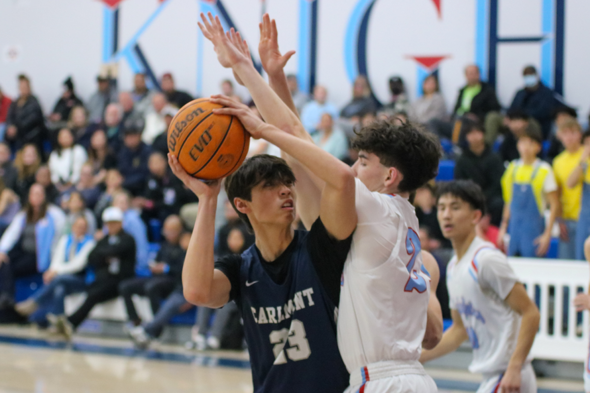 Carlmont sophomore Jordan Rice keeps the ball away from his defender as Rice is pressured. Rice finished the game with 16 points, playing a crucial role for his team. "I'm looking forward to CCS," Rice said. "I feel like that's a big thing for our team and I feel like we could actually go far and do well this year." 