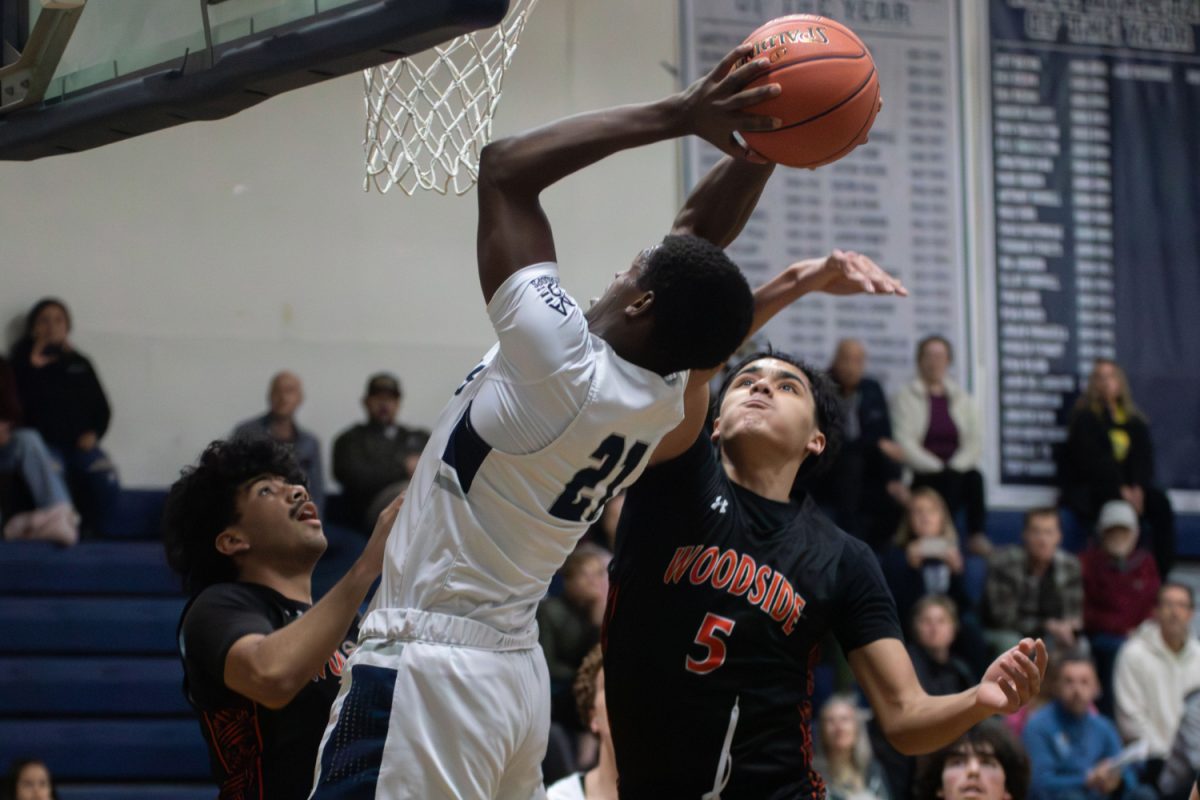 Senior Jeremiah Phillips goes up for the shot while two Woodside defenders try to stop him. Phillips made the shot and was quick to get back on defense. The Wildcats had little success stopping the Carlmont offense throughout the night. “The energy felt it was high. This is a team that isn't as good as us, so we definitely want to show that we were better,” said Emil Gordi said. 
