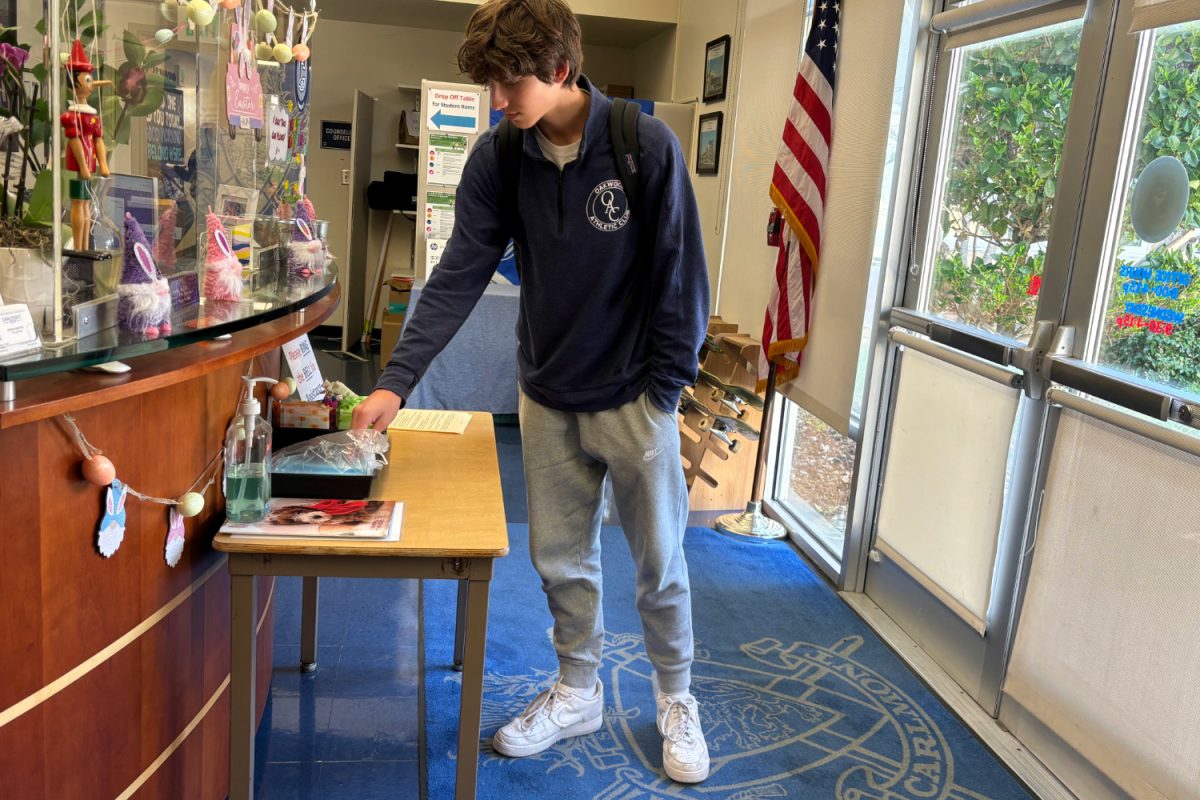 A student grabs a mask from the office. Although masking is appropriate when feeling sick with a runny nose, frequent hand washing is the most important safety measure, according to Erica Quintana, Carlmont's health aide.