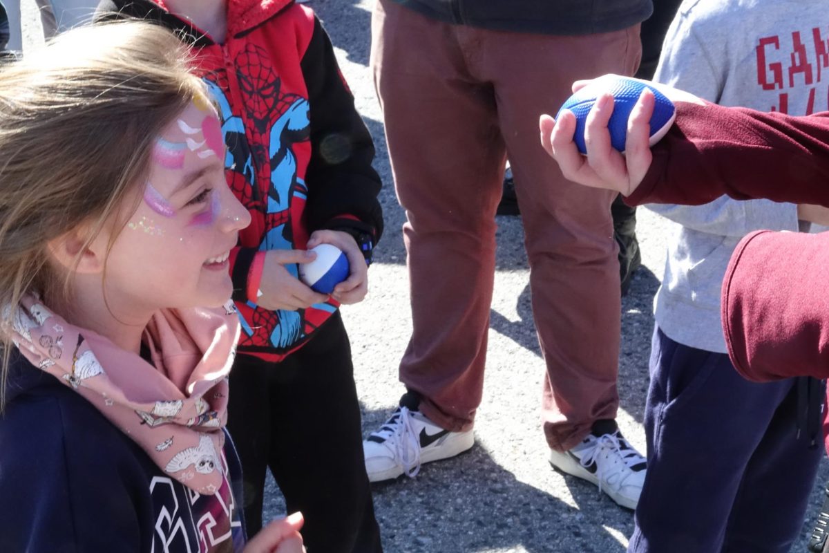 A girl receives a foam football after the the helicopter drop as part of Hiller's Flying Football Fun Fest. The event included many events that combined the principles of aviation with football to create fun for all ages. "If you can do it with a helicopter, we do it," said Vice President of Operations and Marketing Willie Turner.