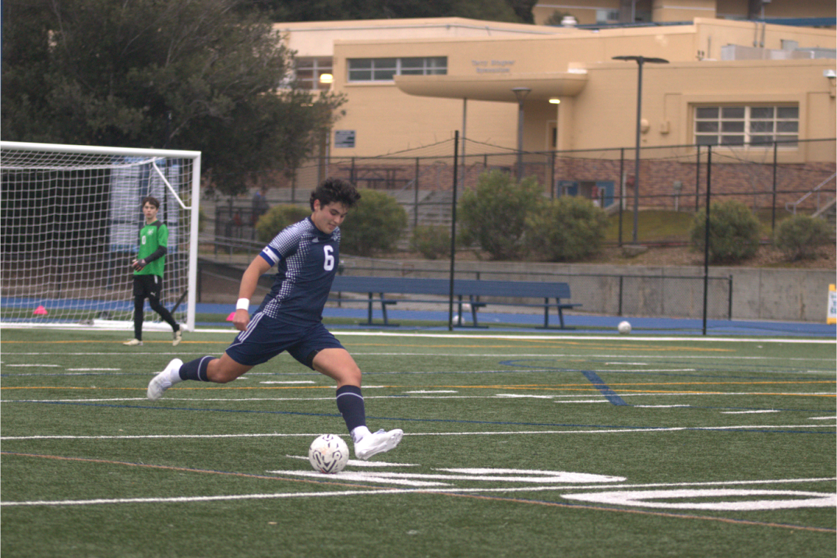 Senior captain Derek Rowe prepares to hit a long ball to his forwards into the Warriors' half. Prior to this, Rowe had a successful defensive tackle to prevent a Warrior counterattack. In soccer, a long ball is an essential component if placed accurately into the space in front of the attacker, ultimately allowing for a boosted attack. 