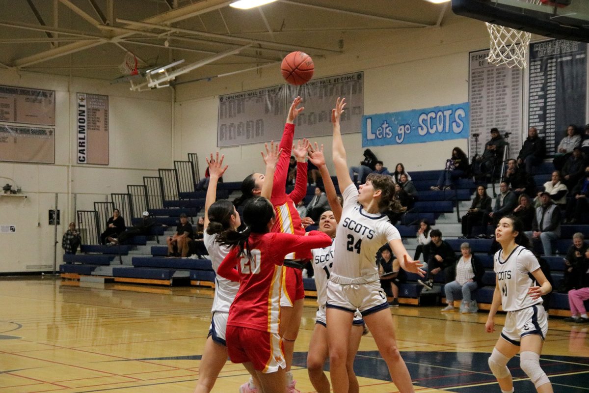 Carlmont senior Arianna Vasiliev fights for the rebound after her teammate shot the ball. Mills ended up with the ball but missed the shot once they had possession. “We took a lot of good shots. Our bench energy was definitely really good. We were all hyped up for each other after every shot,” said Emerson Barajas. 