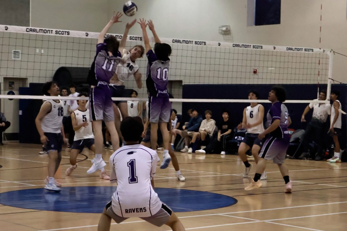 Noah Meeks spikes the ball to the Ravens. Sequoia's libero, Bryan Kim, watched as his teammates jumped up attempting to block the ball. “Carlmont’s blocking this game was really good. We, got a lot of blocks, so we hurt their confidence, which led us to the victory," said Scots junior Erik Gordi. 