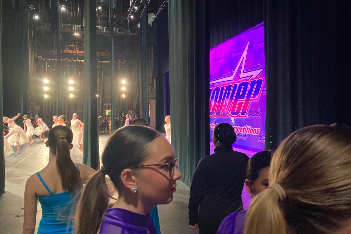 Dancers wait backstage for their turn to perform at a dance competition. Dancers and dance companies globally compete against each other and are judged by a panel of experienced critics.